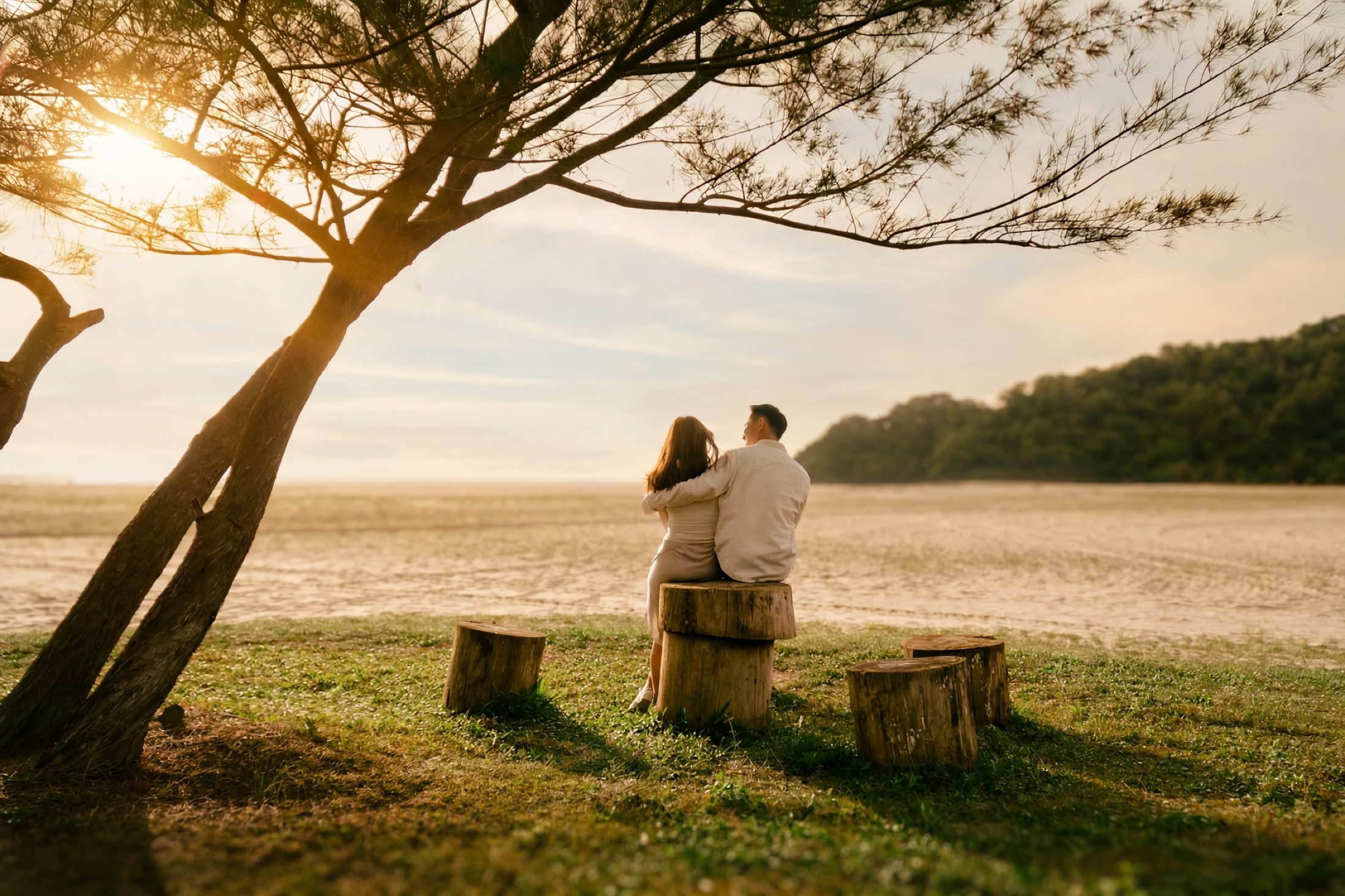 Ian and Phylicia sitting together under a sunset tree